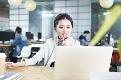 Woman smiling while working on computer