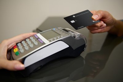 hand with American Riviera Bank credit card at credit card terminal