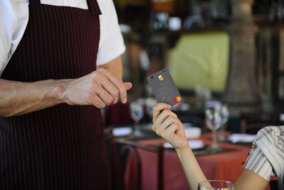 woman handing card to waiter